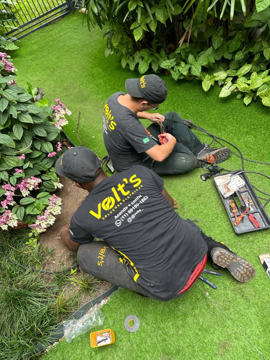 Dois profissionais da Volt's instalando iluminação no jardim