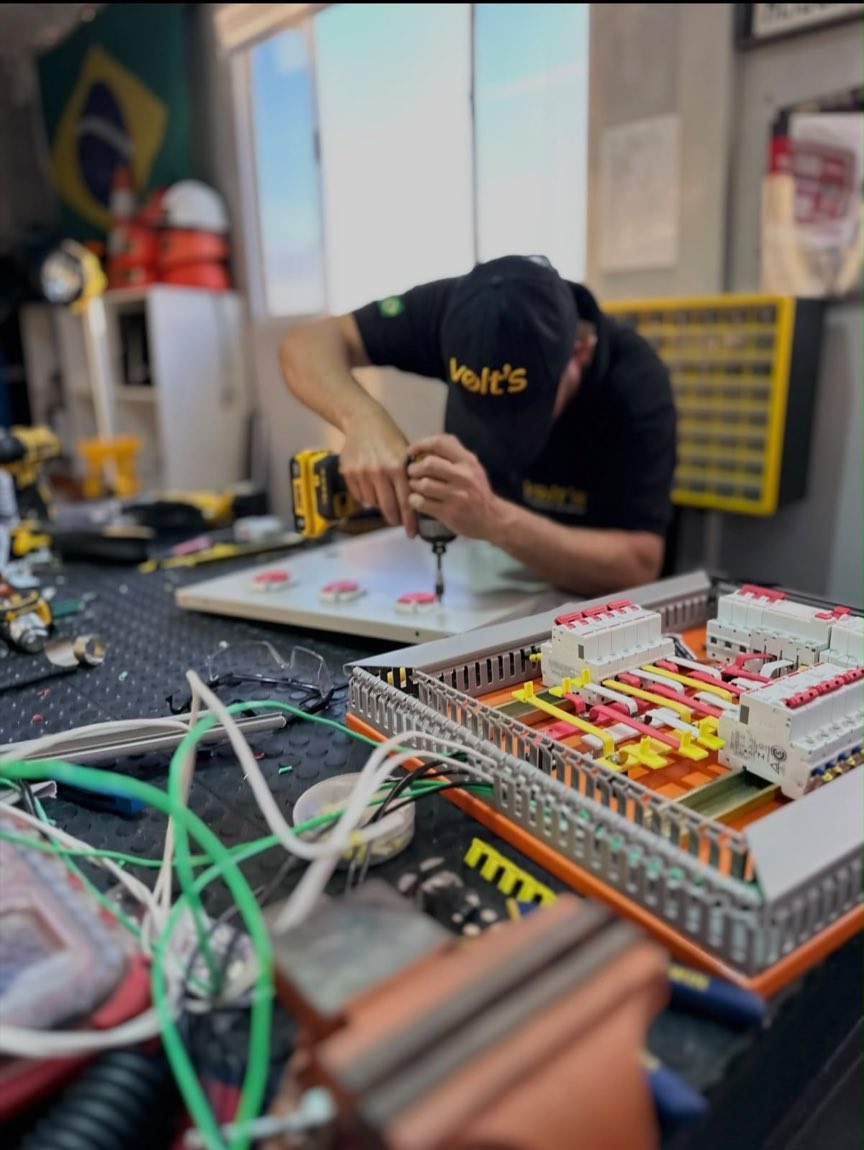 Profissional da Volt's montando painel elétrico na bancada da oficina