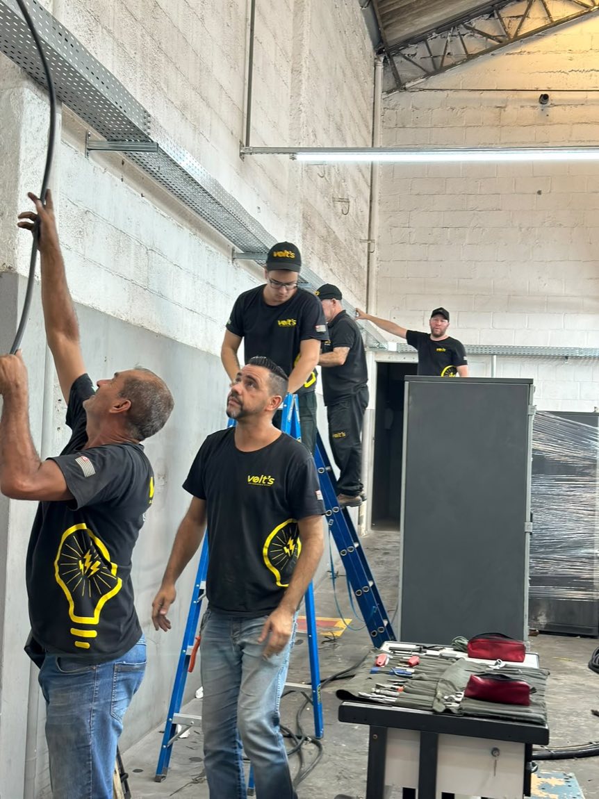Equipe da Volt's trabalhando na instalação elétrica de um galpão industrial